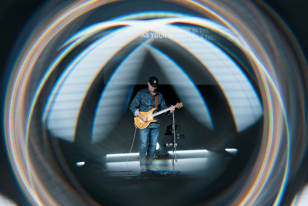 Un uomo che suona una chitarra su un palcoscenico