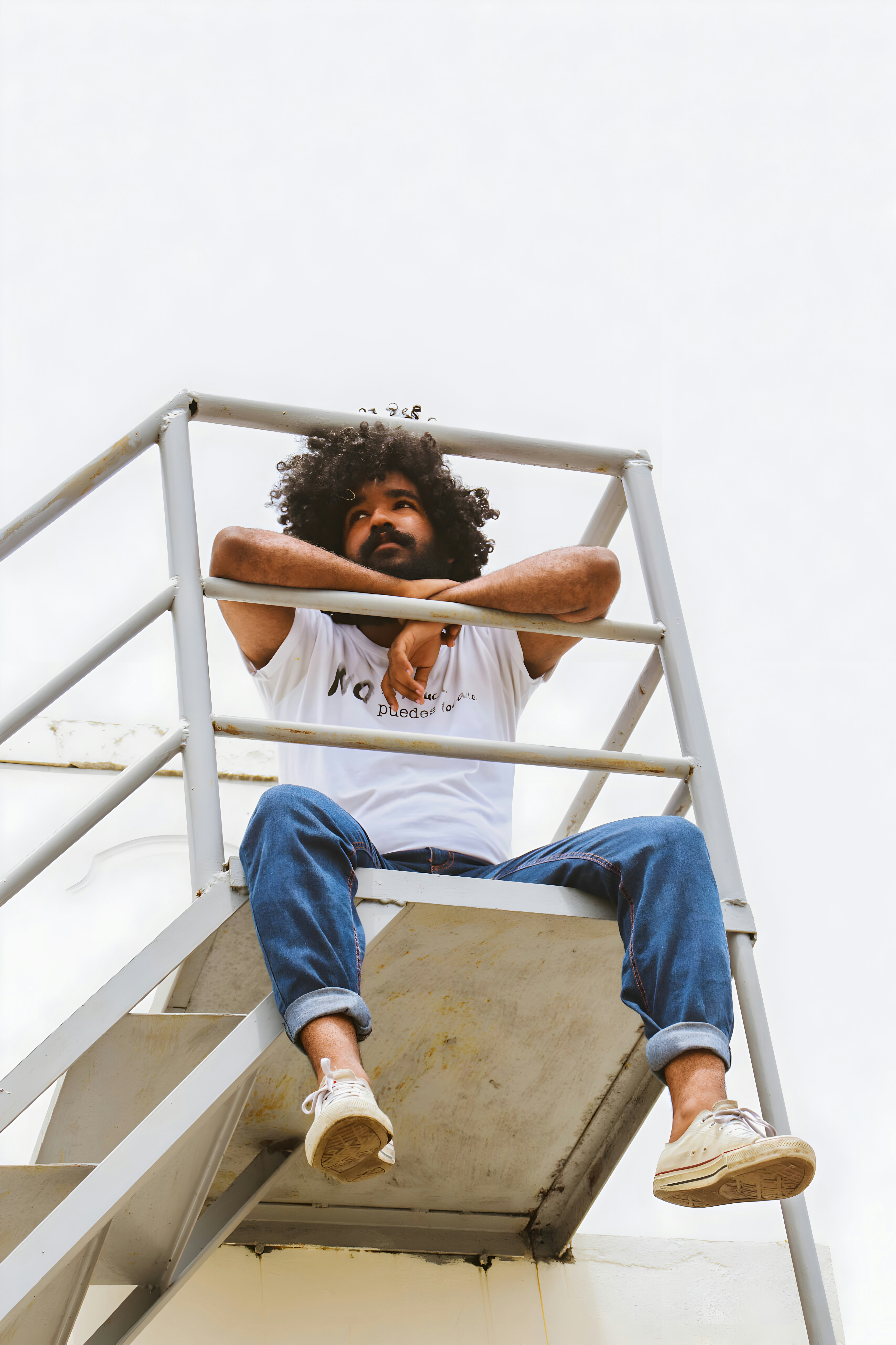 Ein Mann sitzt auf einer Metalltreppe