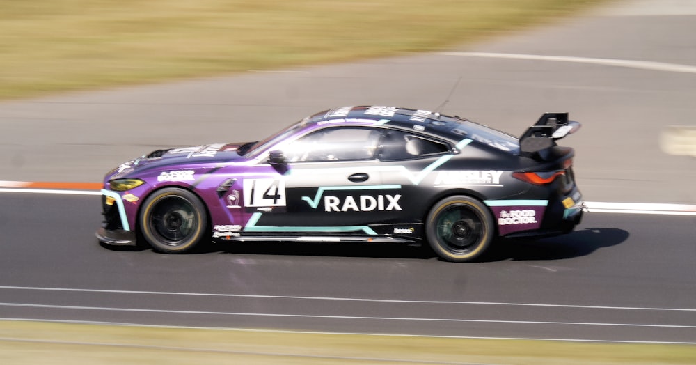 um carro dirigindo em uma pista de corrida com grama ao fundo