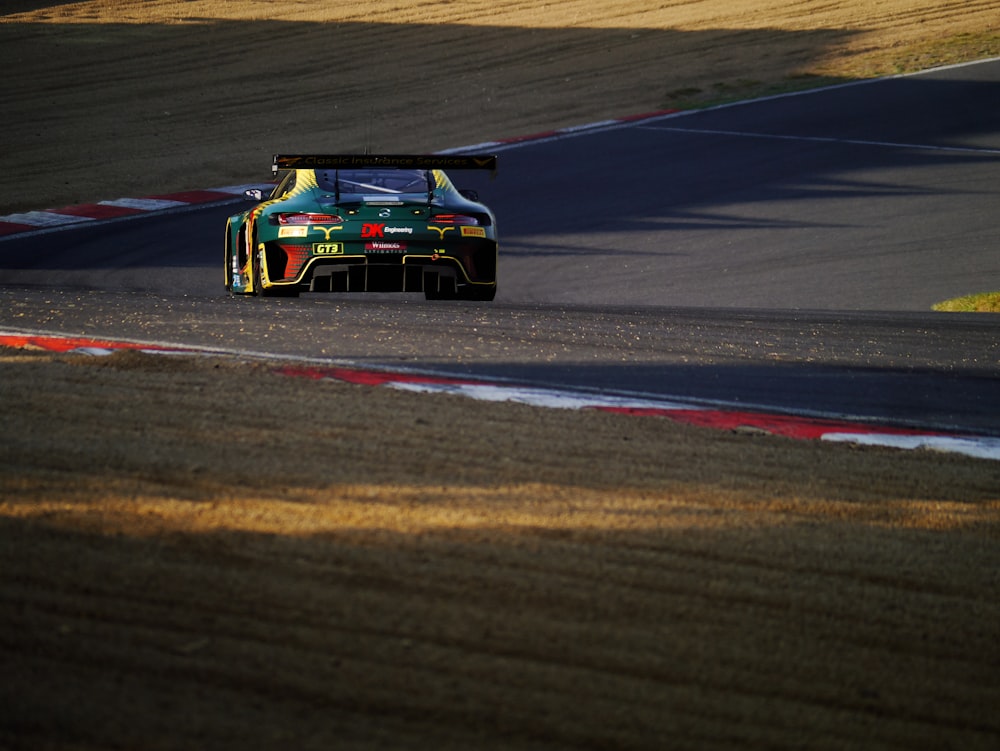 a green race car driving down a race track