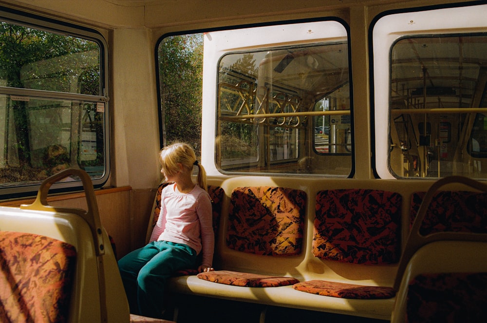 a woman sitting on a bus looking out the window