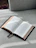 An open book resting on a cozy blanket with soft morning light.