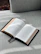 An open book resting on a cozy blanket with soft morning light.