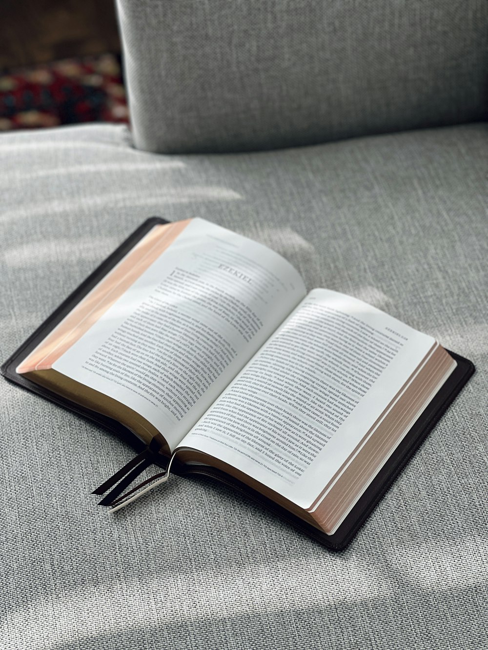 an open book sitting on top of a gray couch