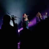 A vibrant choir performing on stage with colorful lights.