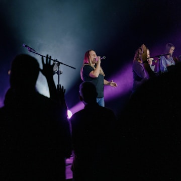 A vibrant choir performing on stage with colorful lights.