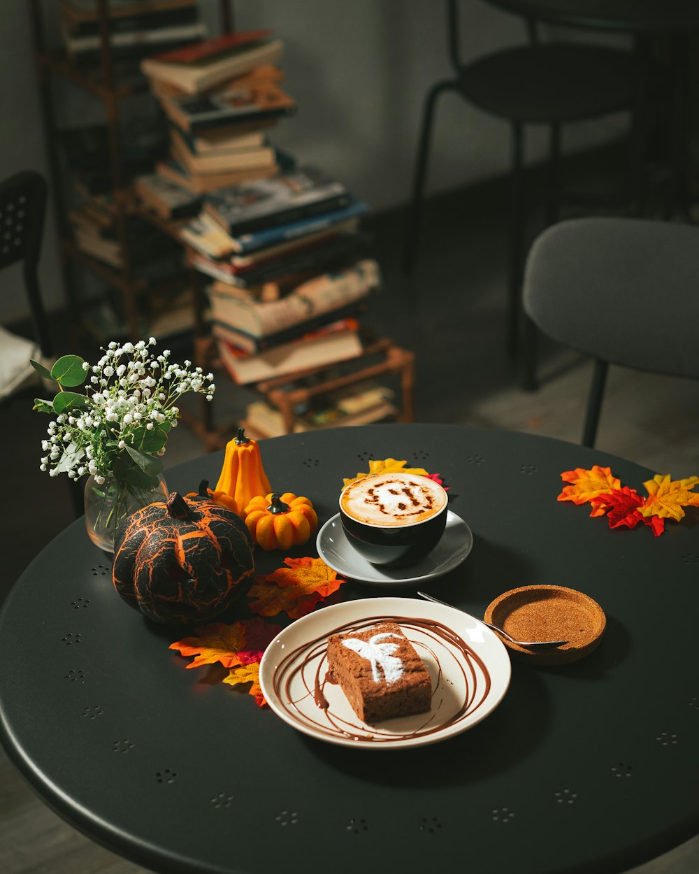 uma mesa coberta com um prato de bolo e uma xícara de café