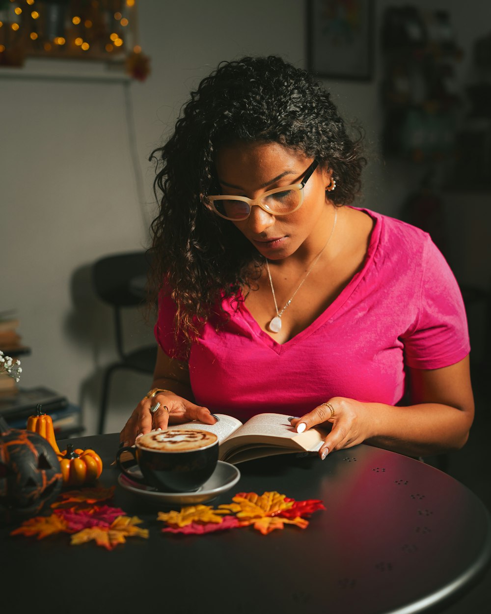 uma mulher sentada em uma mesa lendo um livro