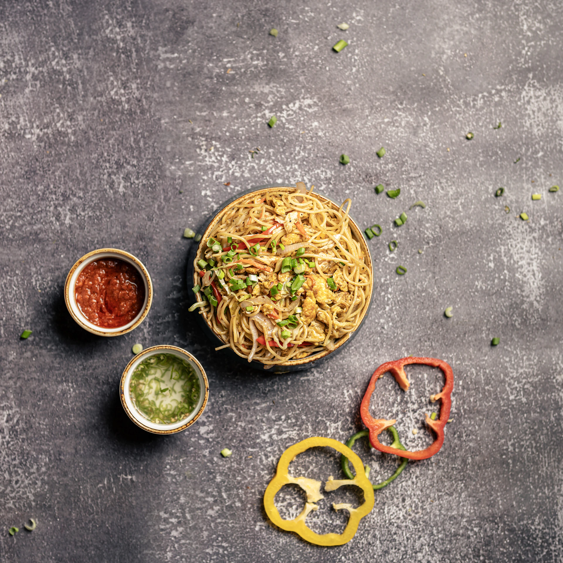 a bowl of noodles and two bowls of sauces