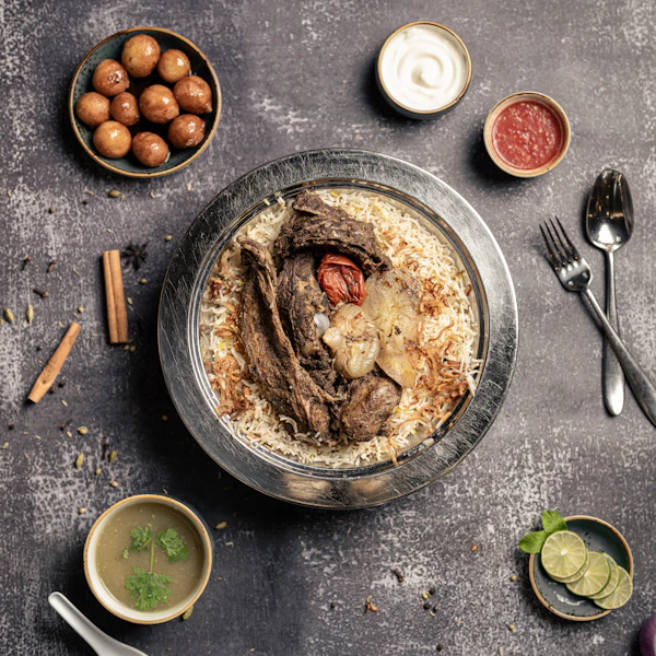 Gheymeh mit Reis, geschmortes Rindfleisch auf Reis, serviert mit Beilagen