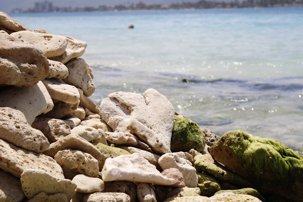 a pile of rocks sitting on top of a beach next to the ocean