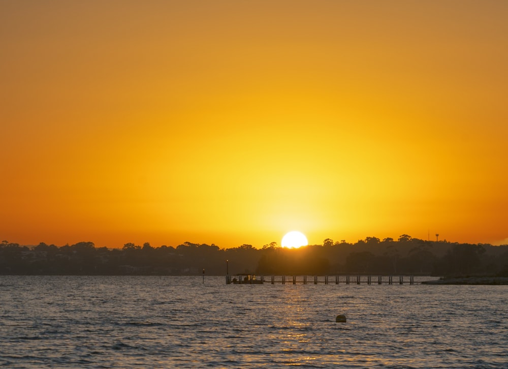 the sun is setting over a body of water