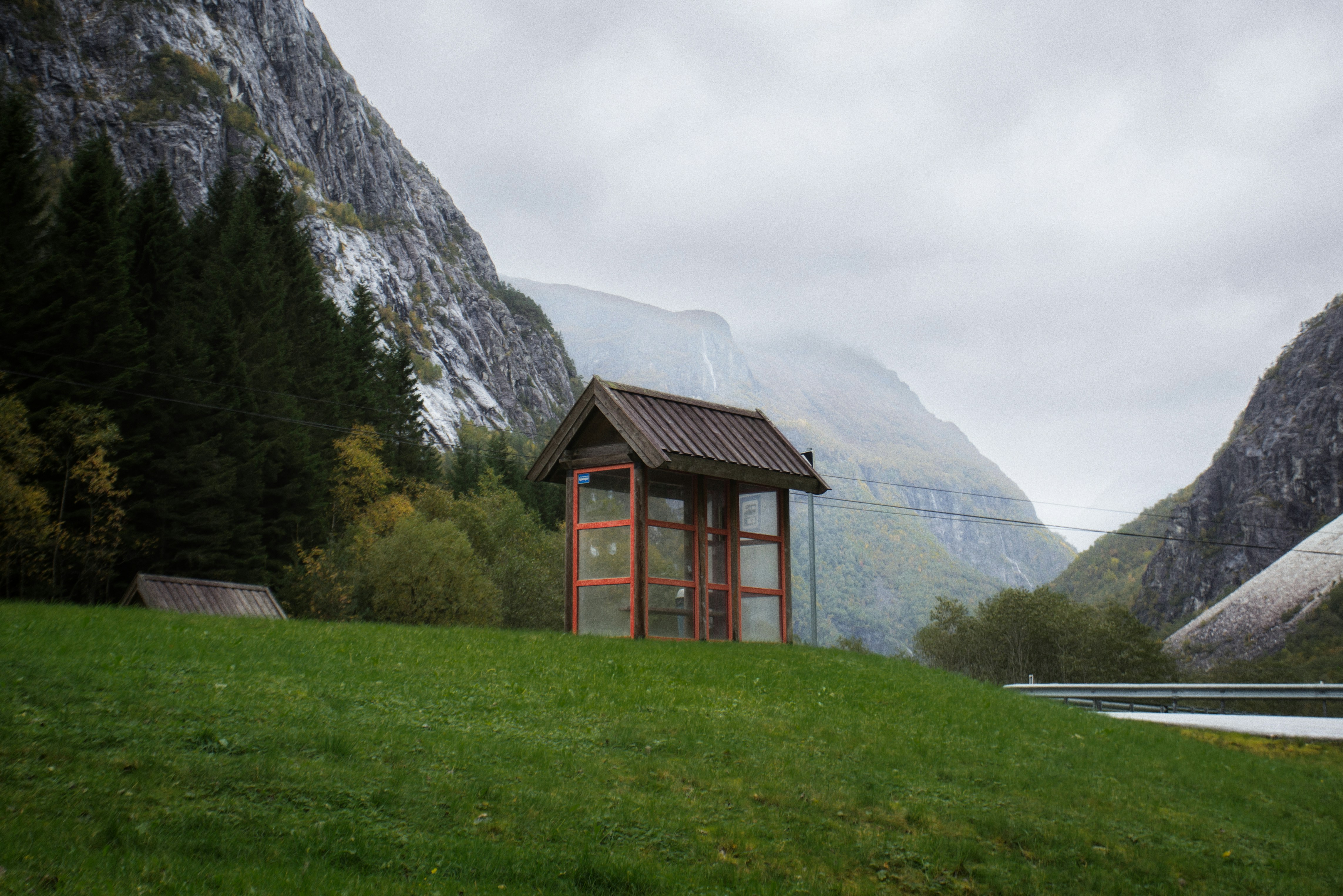 a small wooden shelter on a grassy hill