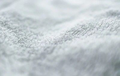 Close-up of a cotton towel’s plush texture with delicate stitching details.