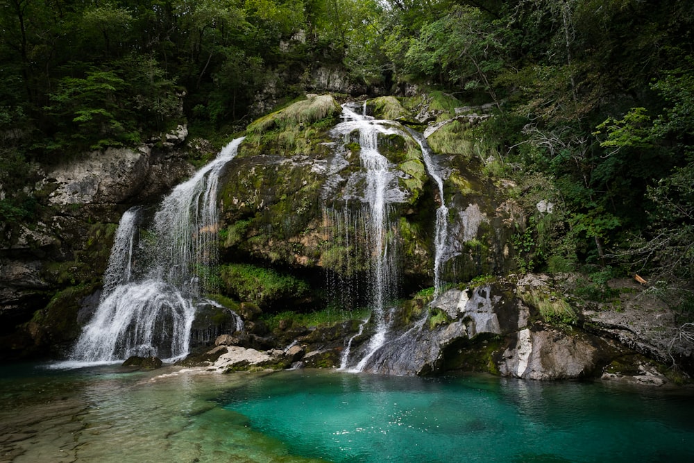 a small waterfall in the middle of a forest