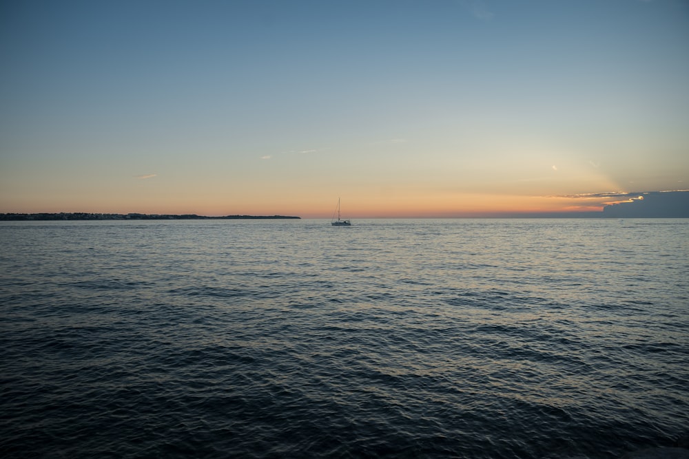 a boat is out on the water at sunset