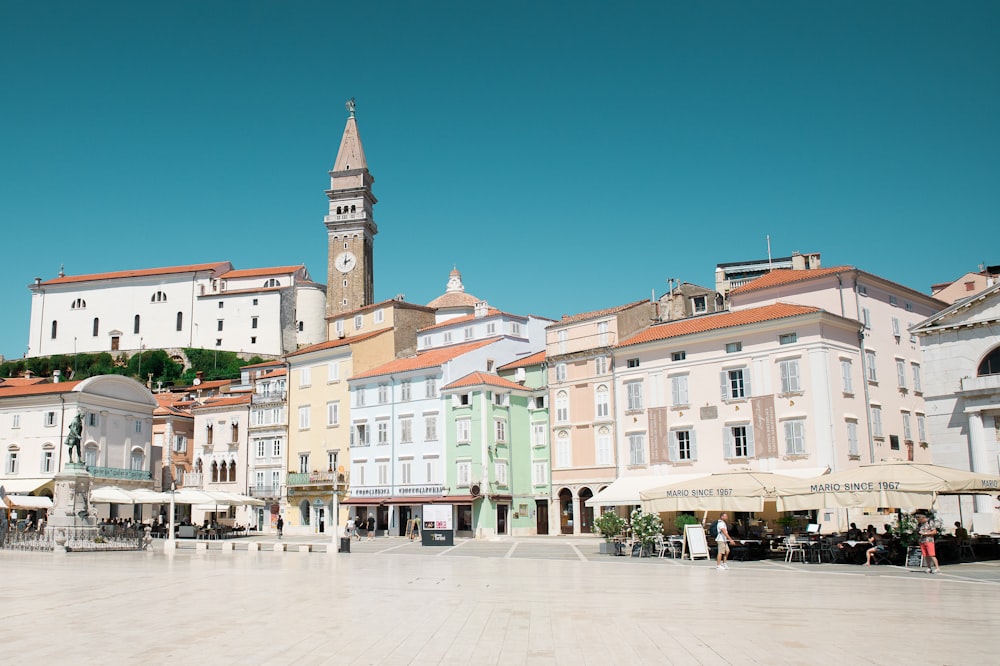 a town square with a clock tower in the background