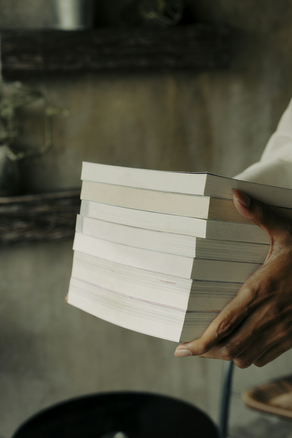 a person holding a stack of books in their hands