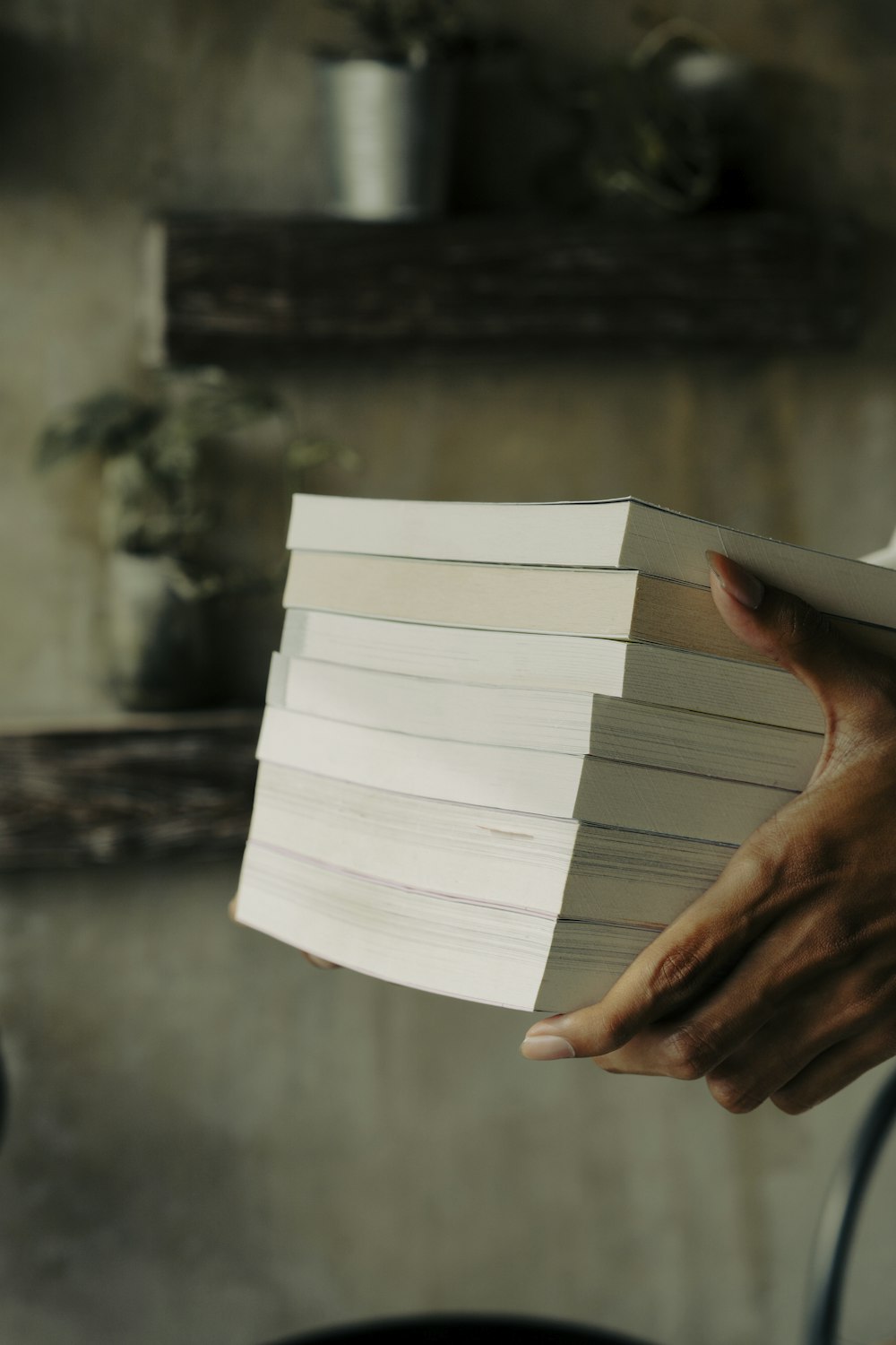 a person holding a stack of books in their hands