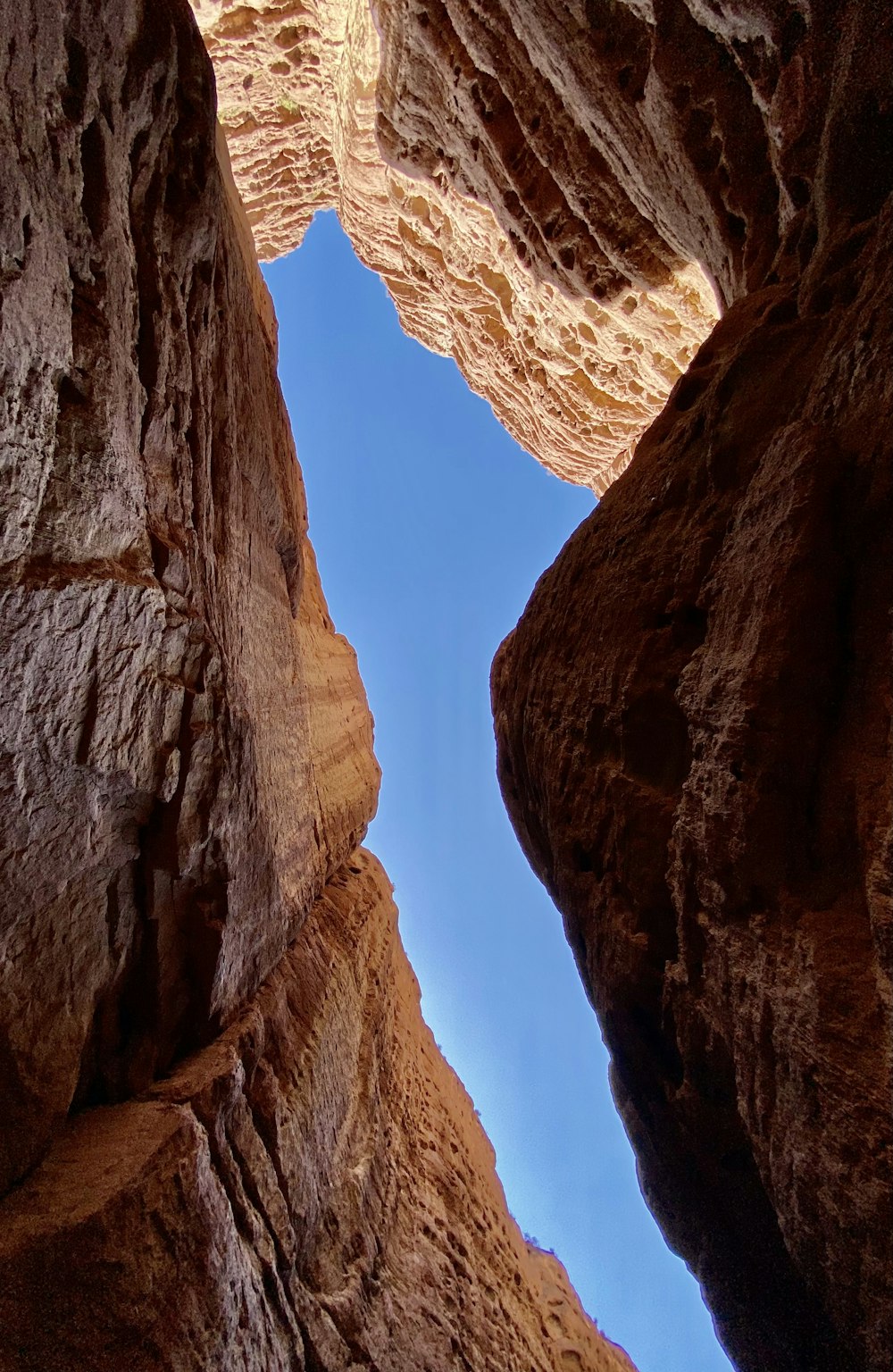 a narrow canyon with a blue sky in the background