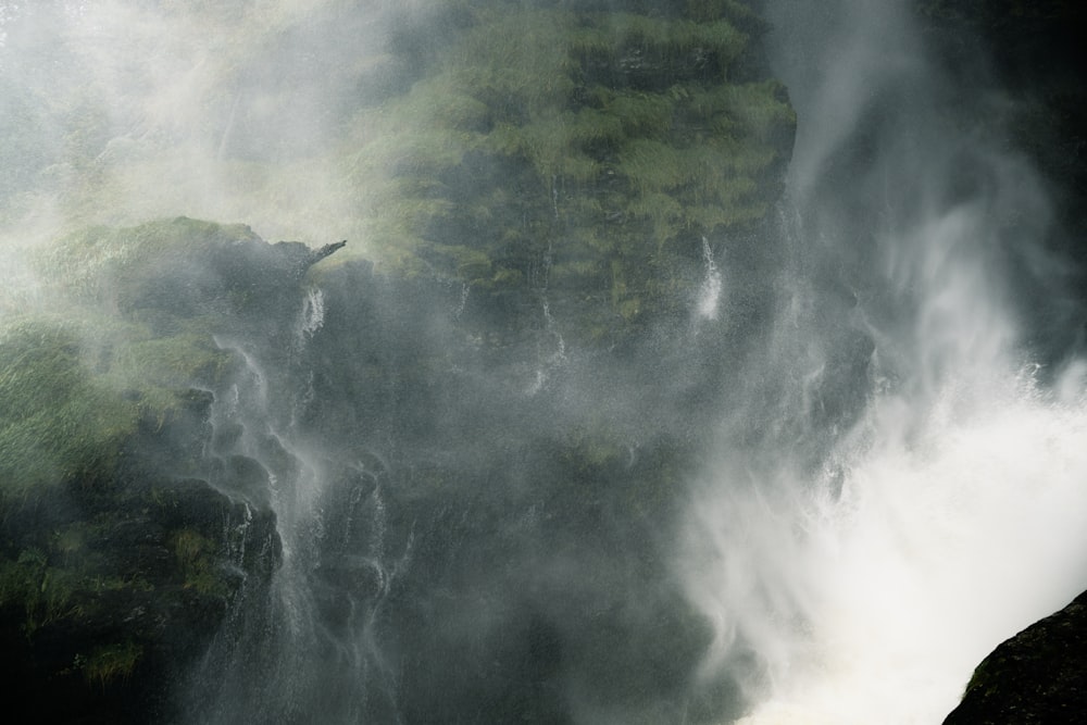 a large waterfall with mist coming out of it