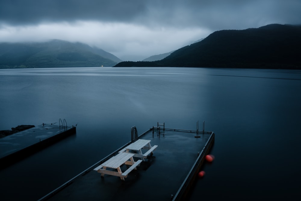 a boat sitting on top of a body of water under a cloudy sky