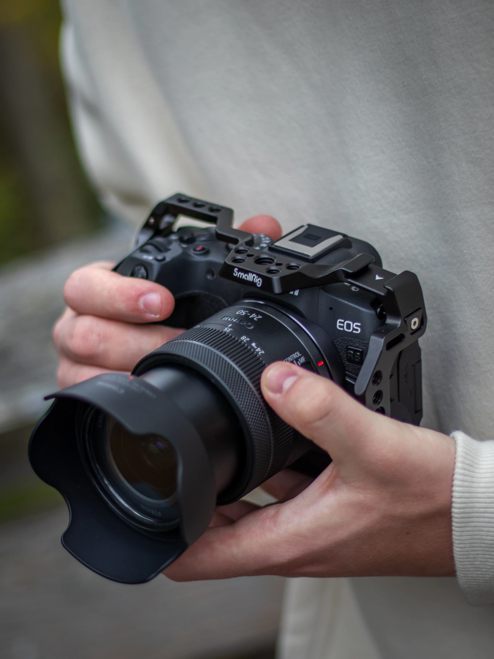 Hands holding a Canon EOS R with lens