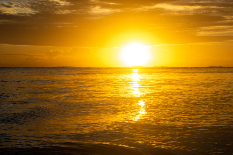 Serene sunset over the ocean with vibrant hues casting a warm glow across the sky