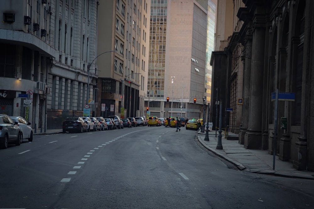 a city street filled with lots of traffic next to tall buildings