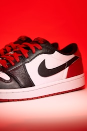 a pair of black and white sneakers with red laces