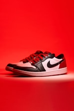 a pair of black and white sneakers on a red background