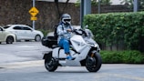 A sleek electric motorcycle weaving through city traffic with eco-friendly packages.