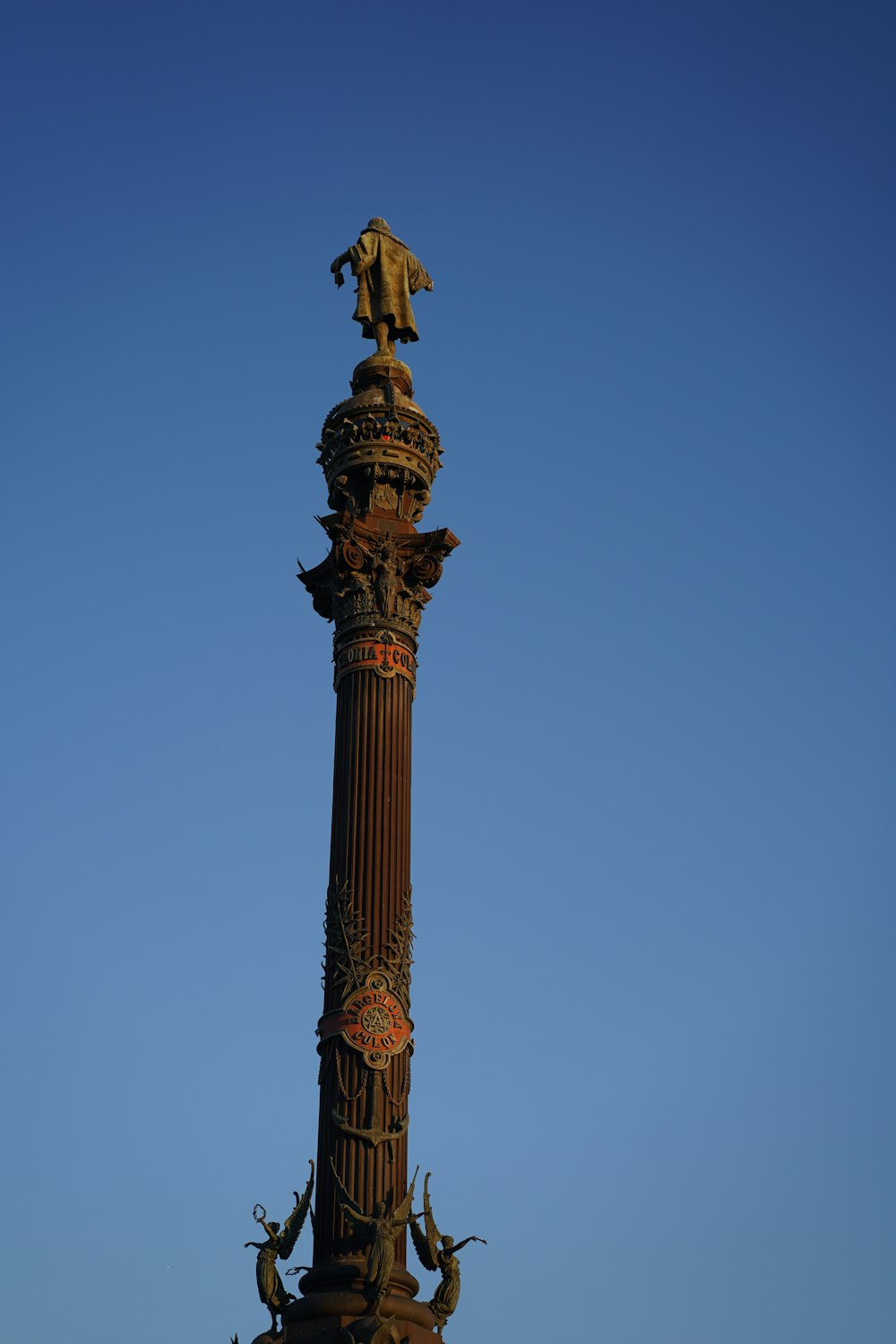 a tall clock tower with a statue on top of it