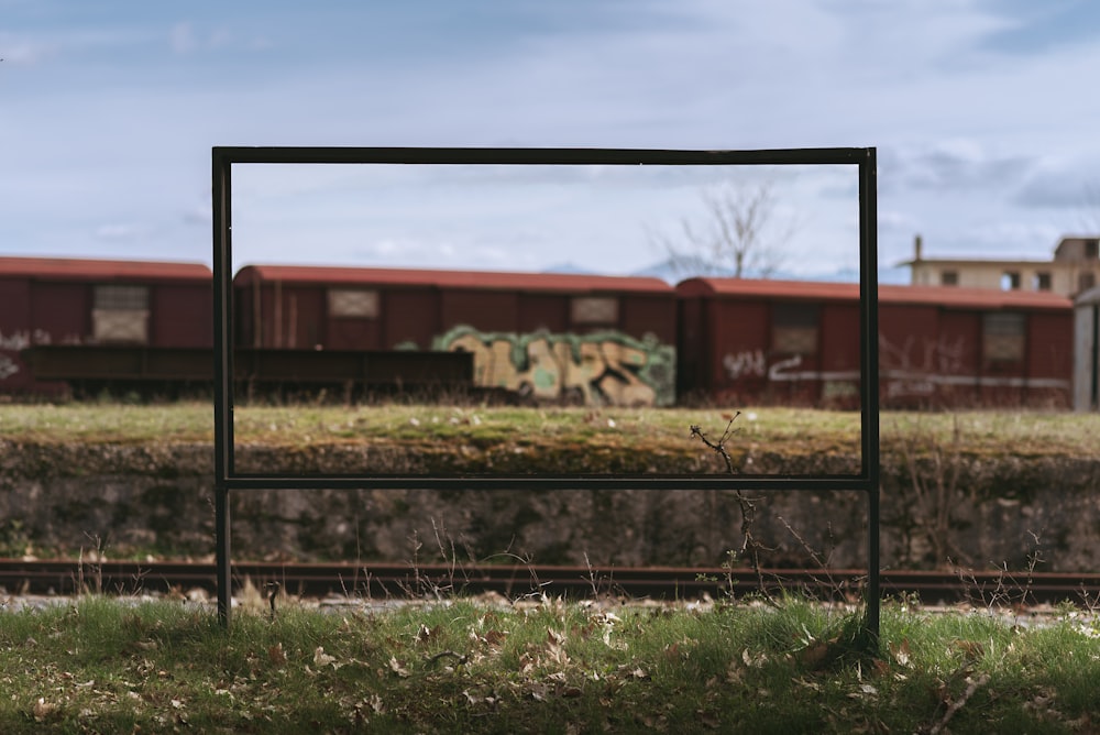 a picture frame sitting in the grass near a train track