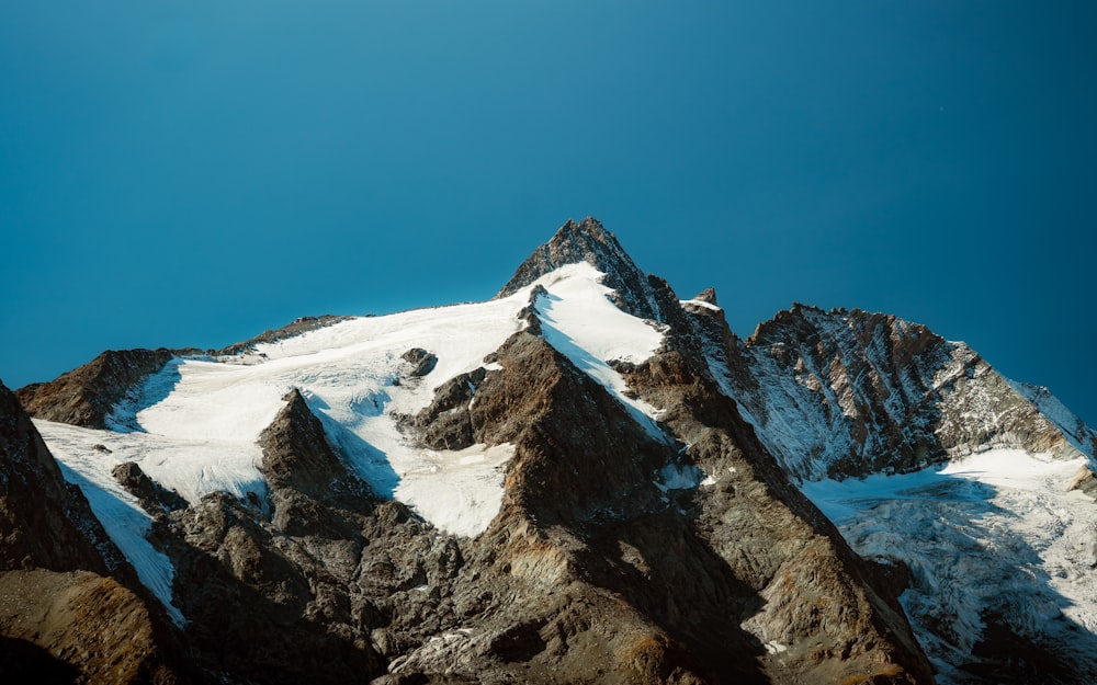 a snow covered mountain under a blue sky