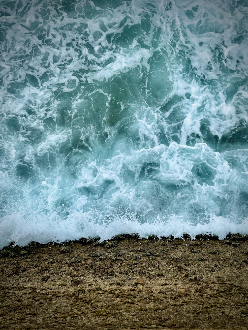 the ocean waves are crashing on the beach