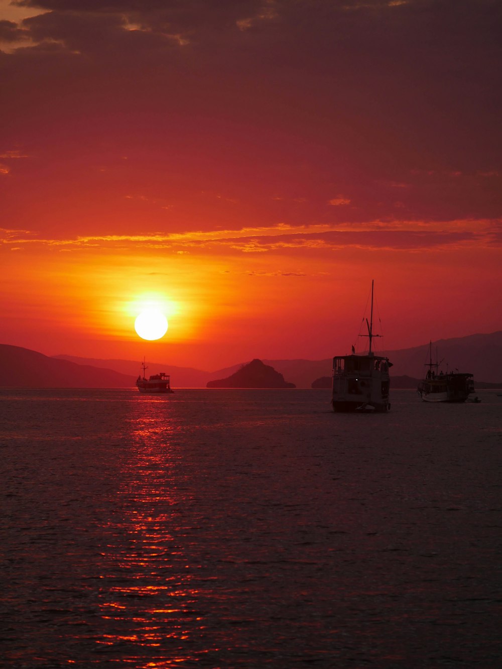 a sunset over a body of water with boats in the water