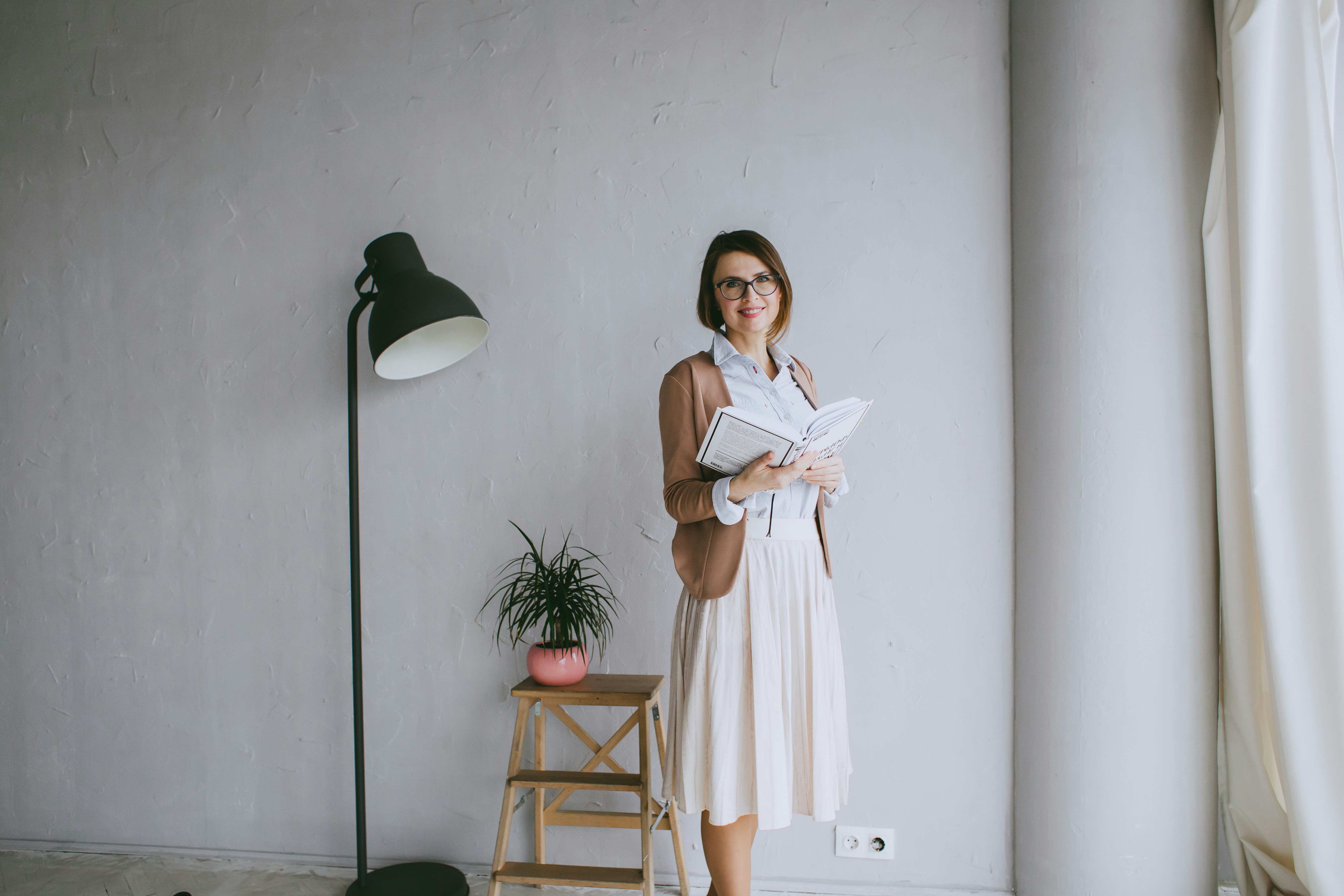 a woman standing in a room holding a piece of paper