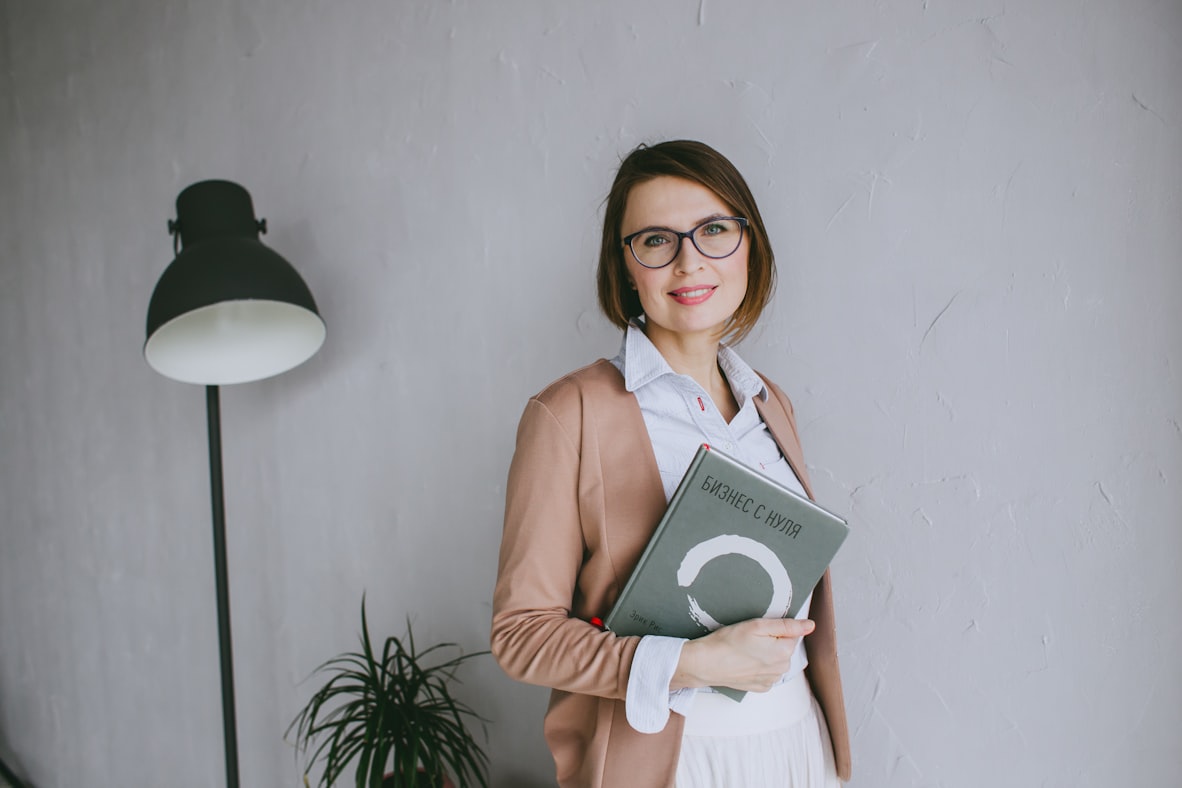 A woman holding a book, reflecting on her business journey