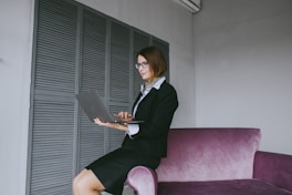a woman sitting on a couch using a laptop computer
