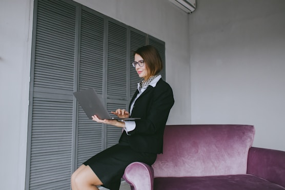 a woman sitting on a couch using a laptop computer