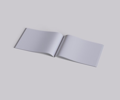 An open blank book lies flat against a solid, neutral background. The pages are empty, displaying a smooth, even texture, and the book's spine is slightly visible.