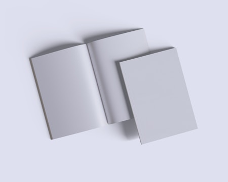 Three plain books are arranged on a light gray background. Two are closed, and one is open in the center, displaying blank pages.