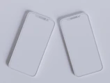 Two mobile phones side by side showing a sleek monochrome and navy website design.