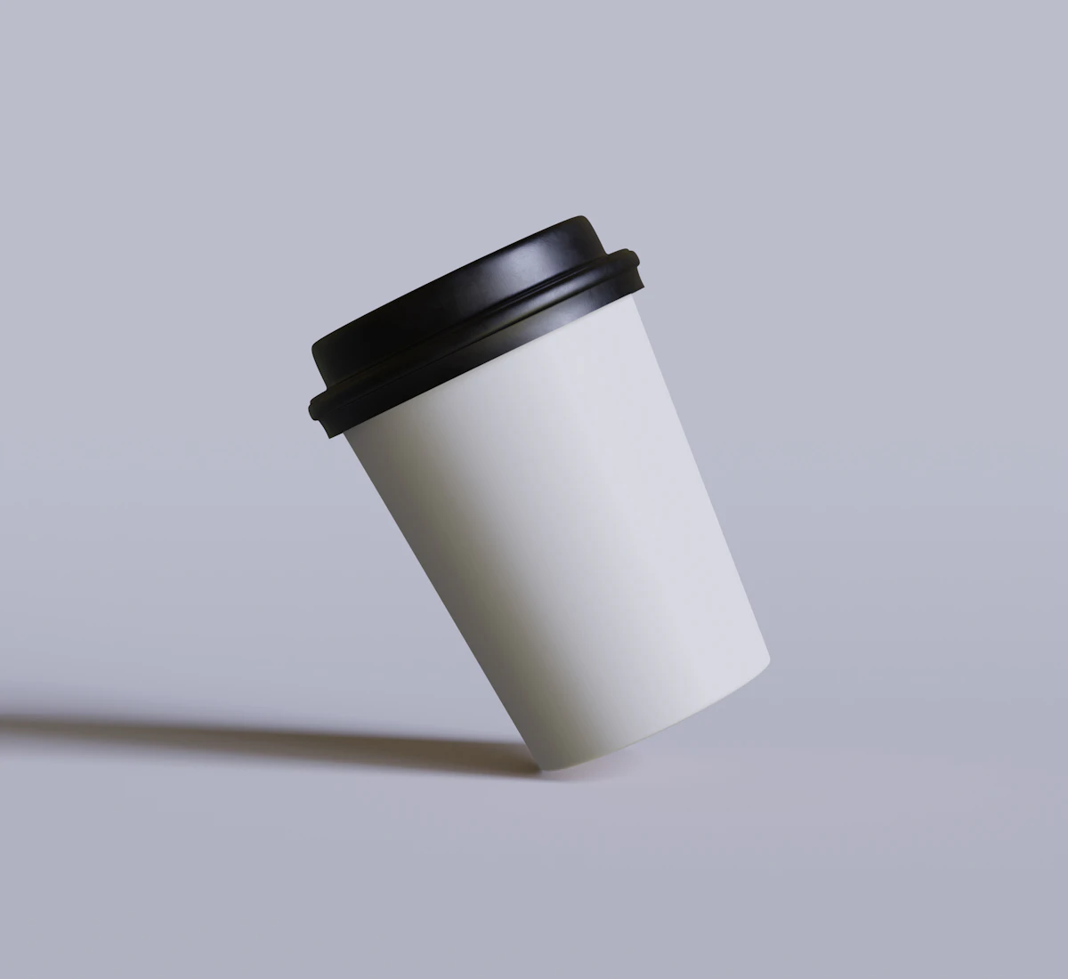 White takeaway cup with a black lid tilted on a lilac surface