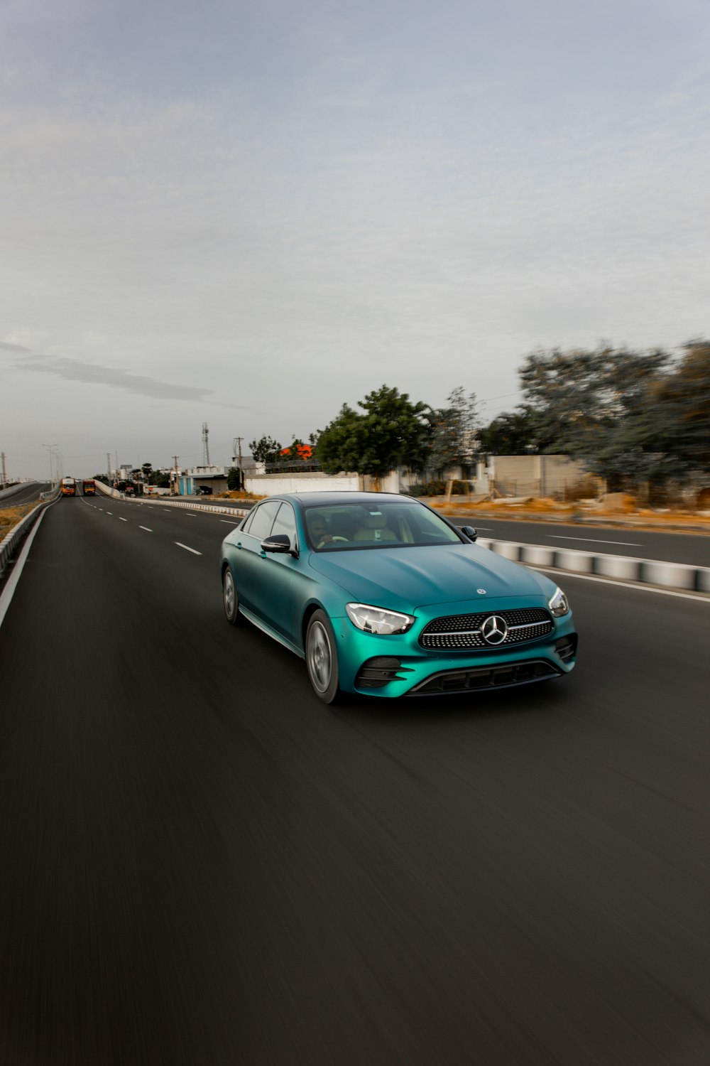 a blue mercedes cla driving down a highway