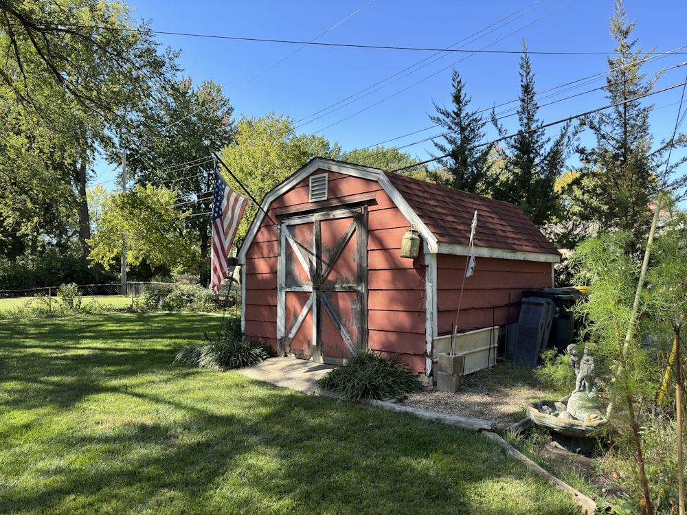 a red barn with a flag on the roof