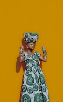 A vibrant portrait of a woman wearing a colorful African print dress designed by ntombenhle, standing confidently against a sunlit urban backdrop.
