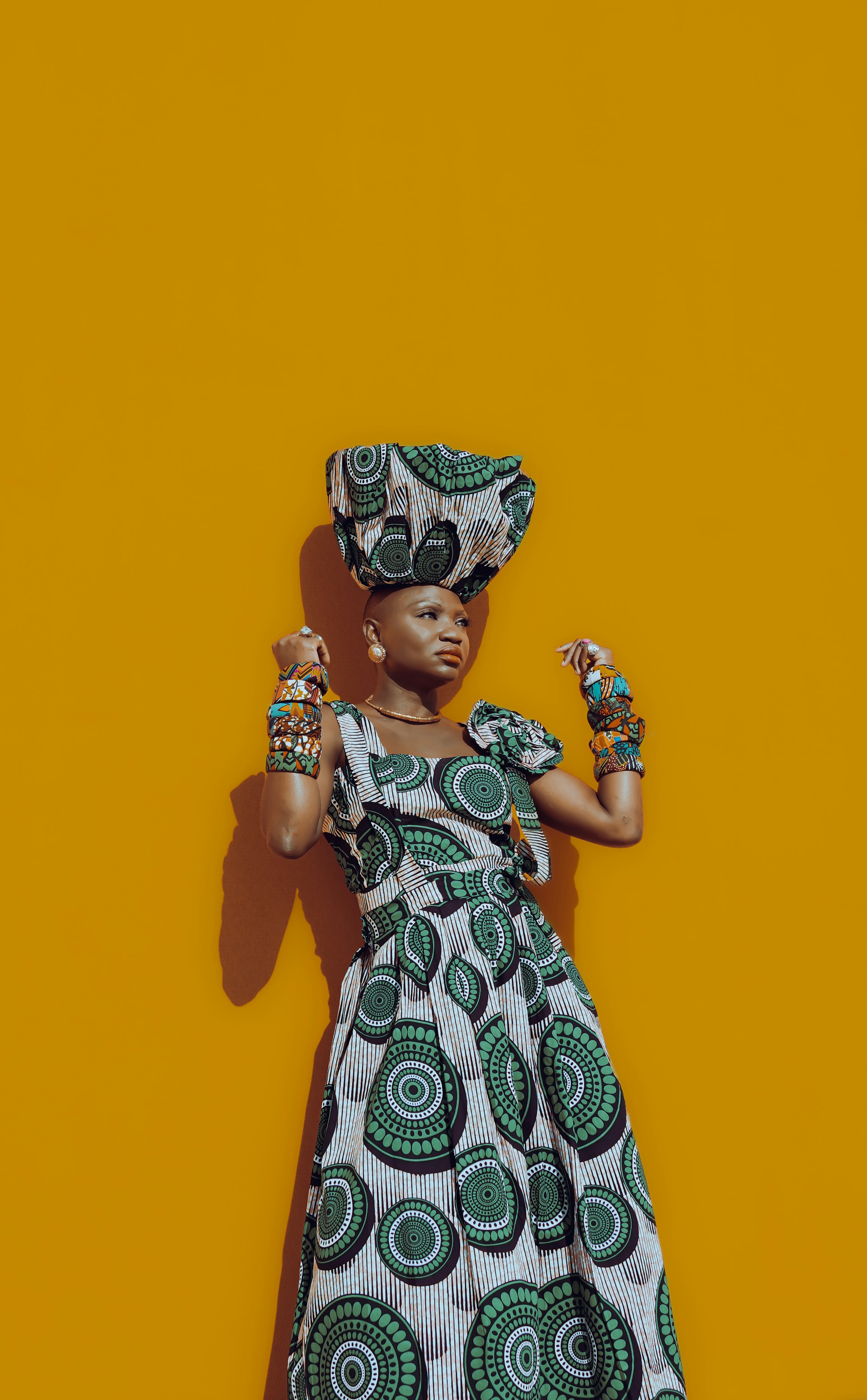 woman wearing yellow long-sleeved dress under white clouds and blue sky during daytime