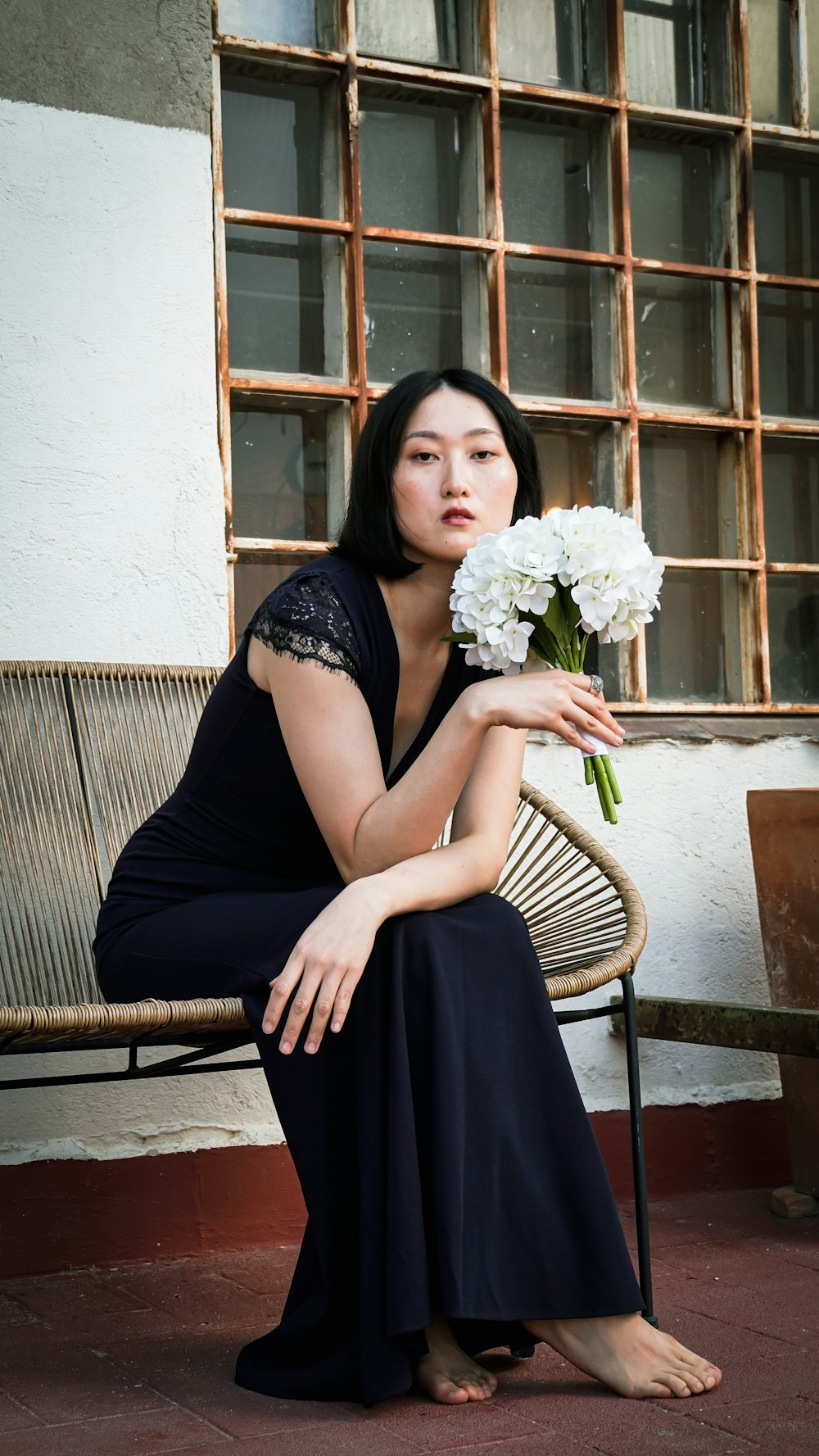 a woman sitting on a chair holding a bouquet of flowers